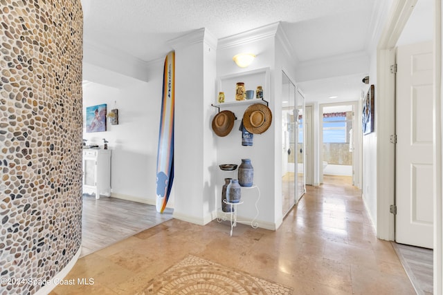 hallway featuring crown molding, light hardwood / wood-style floors, and a textured ceiling