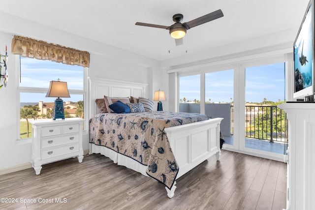 bedroom with wood-type flooring, multiple windows, and ceiling fan