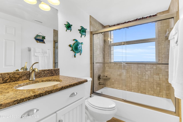 full bathroom with vanity, toilet, and enclosed tub / shower combo