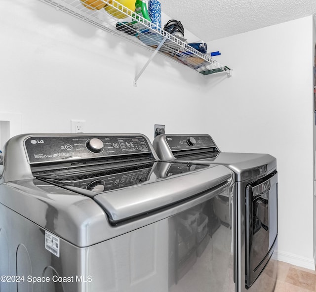 laundry room featuring washing machine and dryer and a textured ceiling