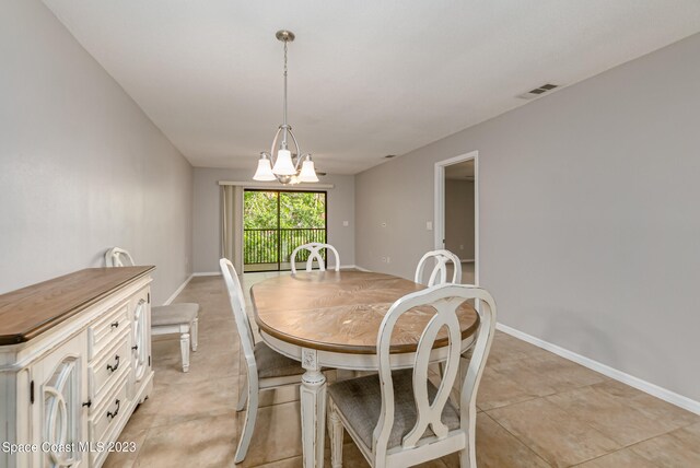 tiled dining space with a notable chandelier