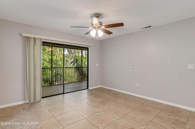 empty room featuring a textured ceiling, light tile patterned floors, and ceiling fan