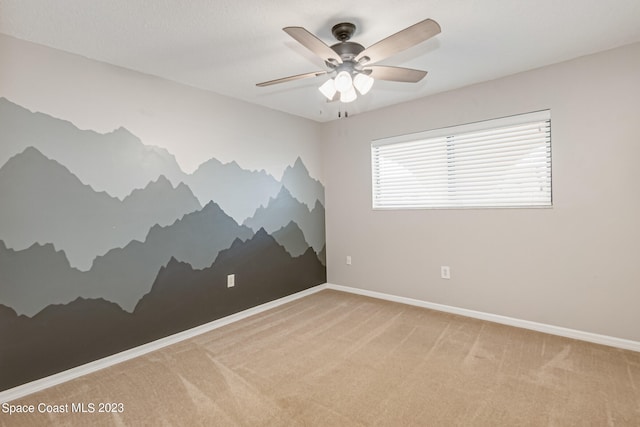 carpeted spare room with ceiling fan