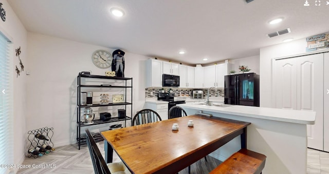 dining area featuring sink and light parquet flooring