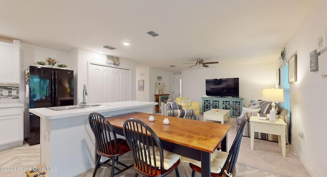 dining space with ceiling fan and sink