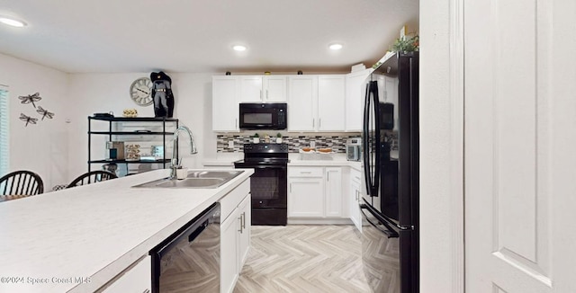 kitchen with black appliances, white cabinetry, sink, and light parquet flooring