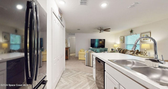 kitchen featuring ceiling fan, sink, white cabinets, and black appliances