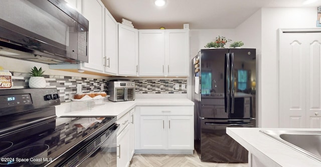 kitchen with decorative backsplash, light parquet flooring, white cabinets, and black appliances