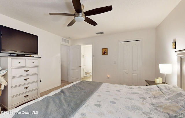 bedroom with ceiling fan, ensuite bath, light carpet, and a closet