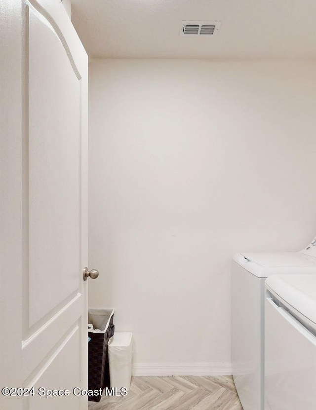 laundry room with light parquet flooring and independent washer and dryer