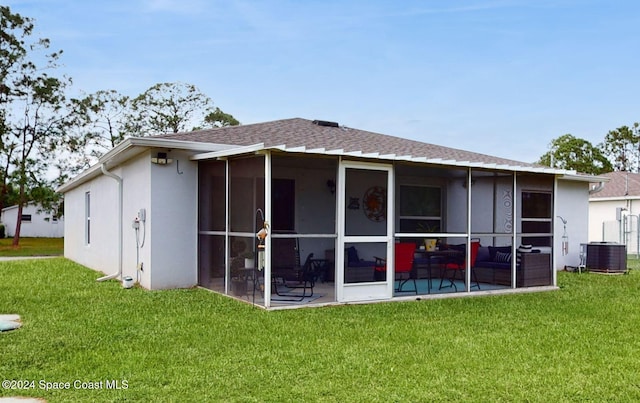 back of property with a lawn, a patio area, a sunroom, and central AC