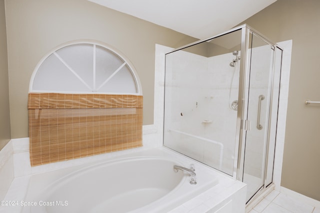 bathroom with tile patterned flooring and separate shower and tub