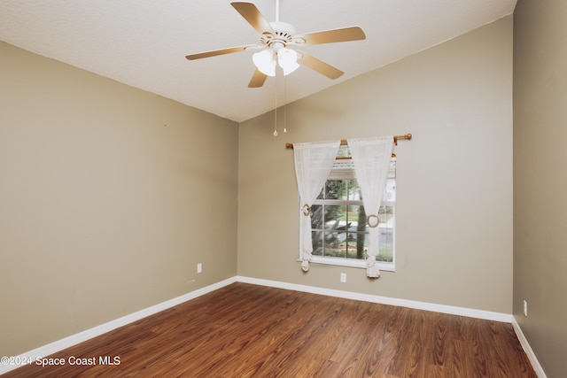 empty room featuring ceiling fan, hardwood / wood-style floors, and vaulted ceiling