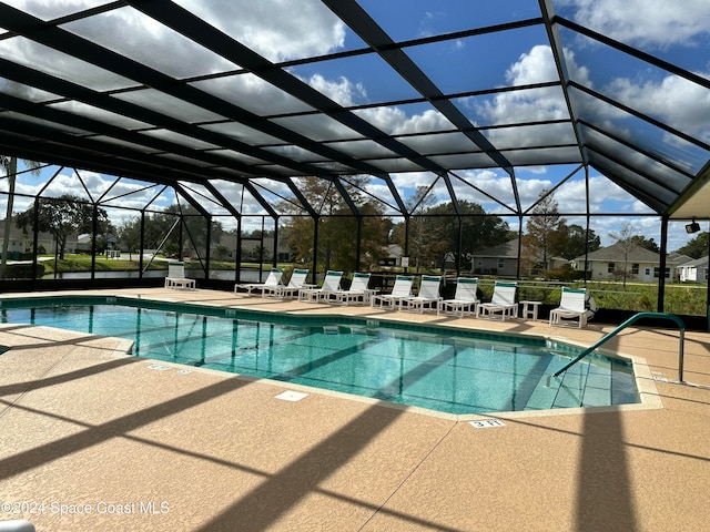 view of swimming pool featuring a patio area and a lanai