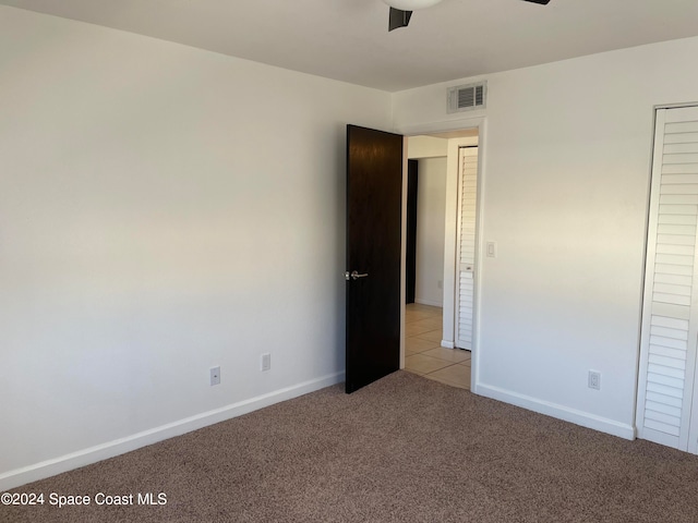 unfurnished bedroom with light carpet and ceiling fan