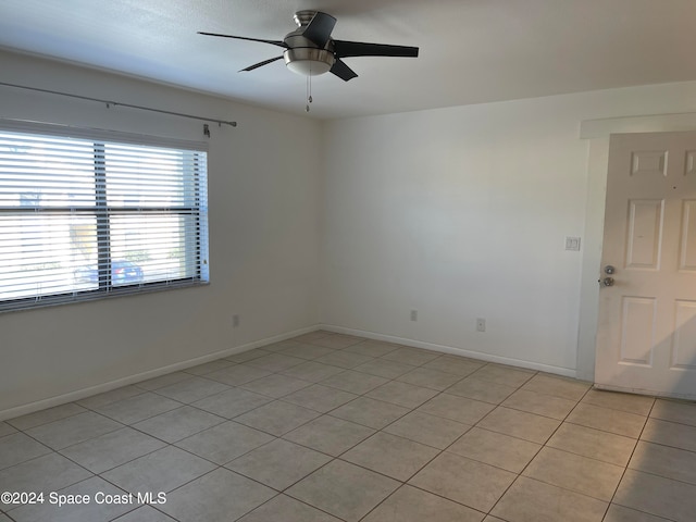 tiled empty room with ceiling fan