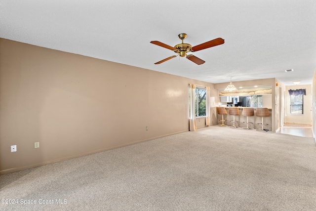 unfurnished living room featuring light colored carpet and ceiling fan