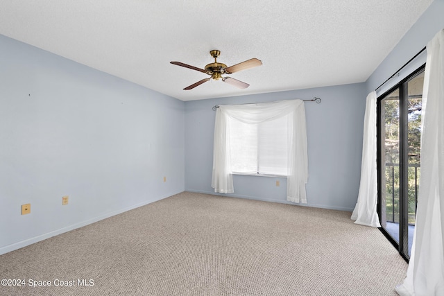 carpeted empty room featuring ceiling fan and a textured ceiling