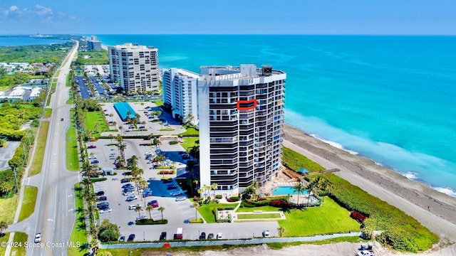 birds eye view of property with a water view and a beach view