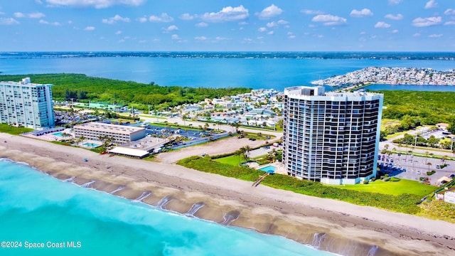 birds eye view of property with a water view and a beach view