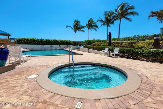 view of swimming pool with a patio and a community hot tub