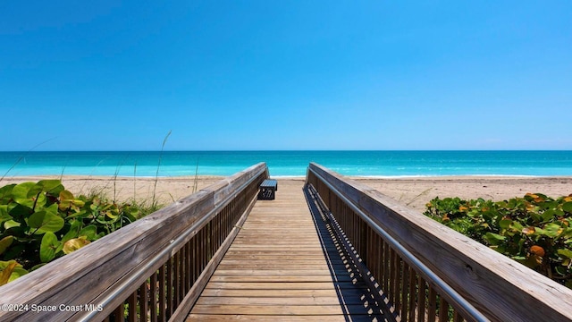 view of home's community with a water view and a beach view