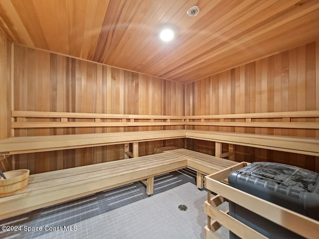 view of sauna featuring tile patterned floors, wooden walls, and wood ceiling