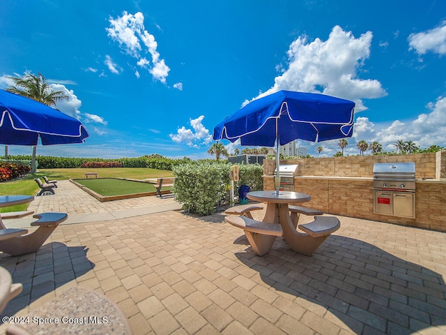 view of patio with area for grilling and a grill