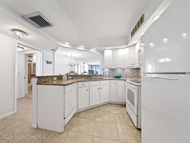 kitchen featuring kitchen peninsula, sink, light tile patterned flooring, white cabinets, and white appliances