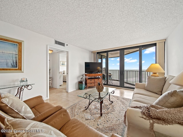 living room featuring a wall of windows, a textured ceiling, french doors, and light tile patterned floors