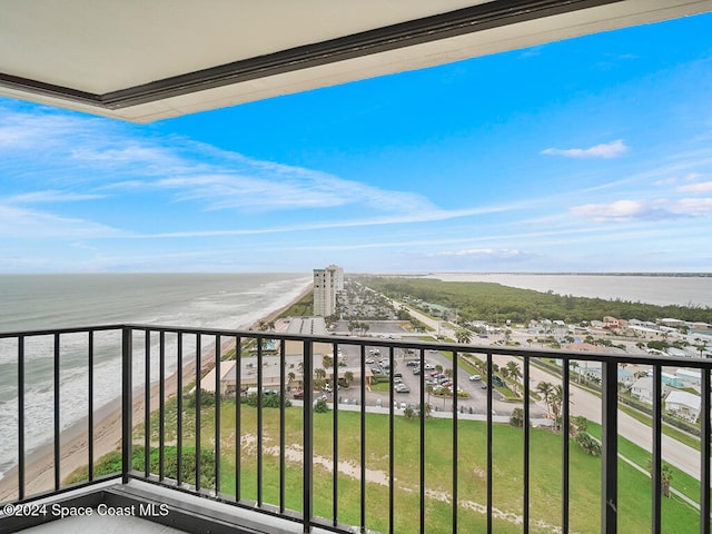 balcony with a water view and a view of the beach