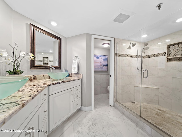 bathroom featuring vanity, toilet, and walk in shower