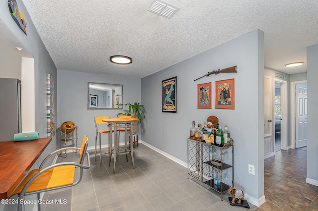 dining room featuring light tile patterned flooring and a textured ceiling