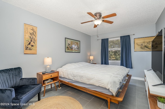 tiled bedroom with a textured ceiling and ceiling fan