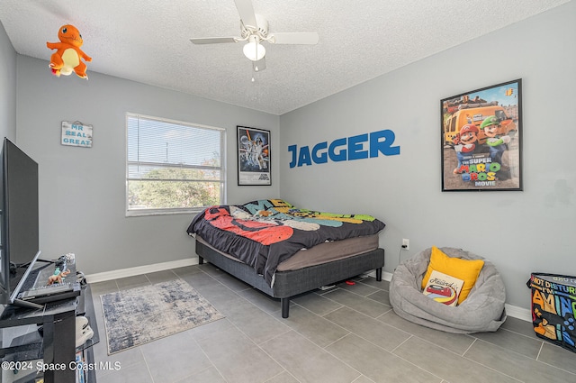 bedroom featuring a textured ceiling, ceiling fan, and light tile patterned flooring