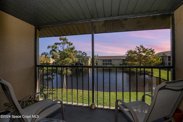 sunroom featuring a wealth of natural light and a water view