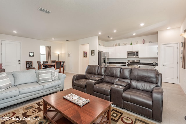 living room featuring sink and light tile patterned floors