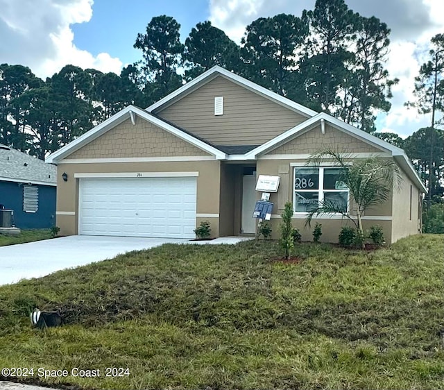 view of front of home featuring a front yard, central AC, and a garage