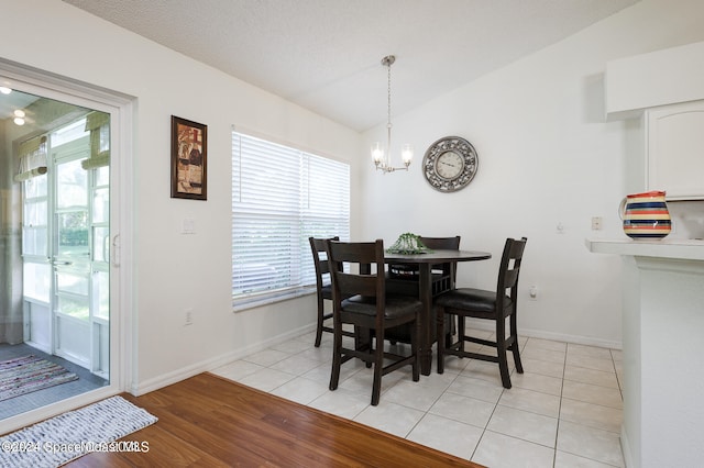 dining area featuring vaulted ceiling, a healthy amount of sunlight, and light hardwood / wood-style floors