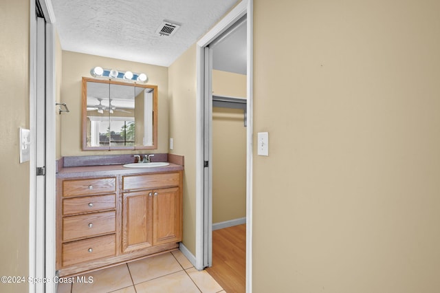 bathroom featuring vanity, tile patterned floors, and a textured ceiling