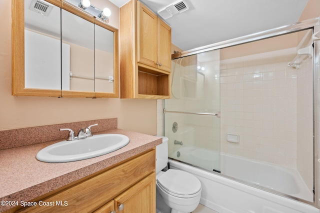 full bathroom with toilet, vanity, and bath / shower combo with glass door