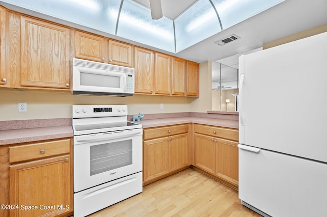 kitchen featuring white appliances, light brown cabinetry, and light hardwood / wood-style flooring