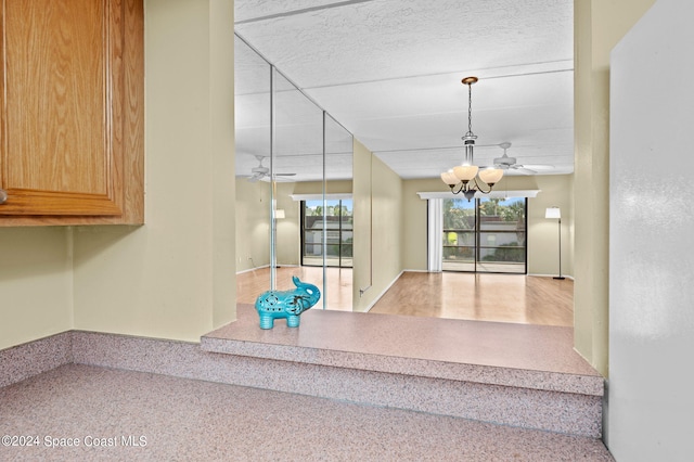 interior space with a textured ceiling and a chandelier