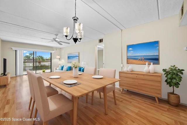 dining space with light wood-type flooring and ceiling fan with notable chandelier