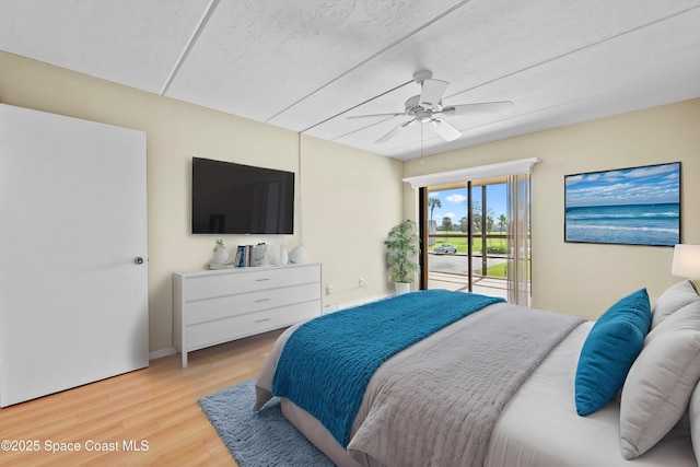 bedroom featuring access to exterior, ceiling fan, and light hardwood / wood-style flooring