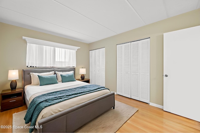 bedroom with two closets and wood-type flooring