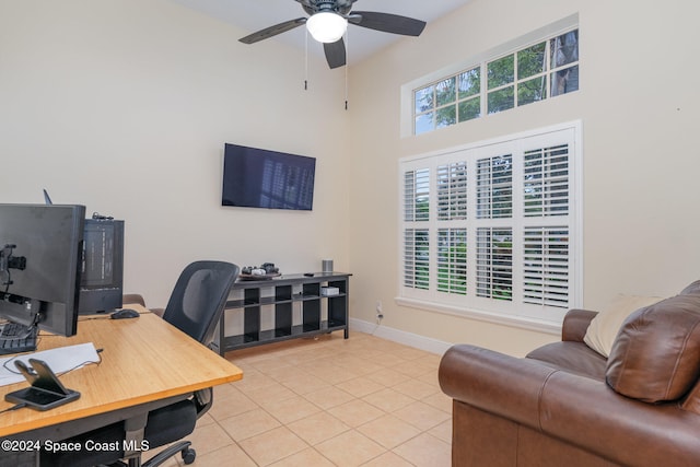 tiled office space with ceiling fan and a high ceiling