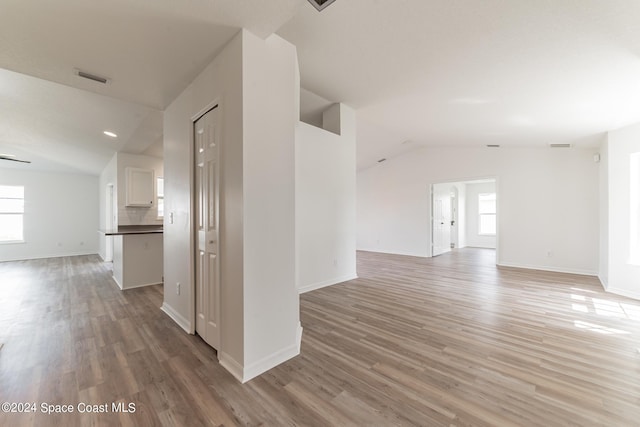 unfurnished room featuring vaulted ceiling and light hardwood / wood-style floors