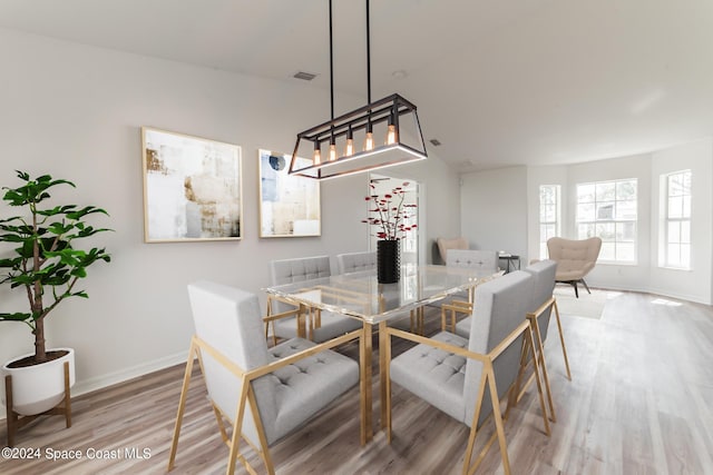 dining space featuring light hardwood / wood-style floors and an inviting chandelier