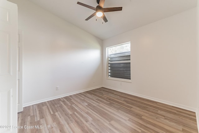 spare room featuring light hardwood / wood-style flooring, lofted ceiling, and ceiling fan